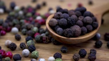 Aromatik baharatlar: Kamera karışık biberler boyunca hareket eder. Tahta kaşıklarda beyaz ve siyah biber.