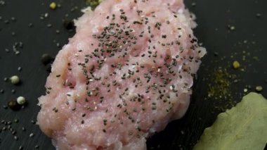 Çiğ tavuk eti, chia tohumu ve baharatla serpiştirilmiş sağlıklı bir protein ürünüdür.
