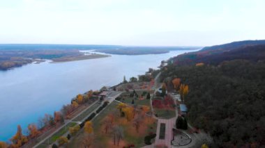 Ukrayna 'nın Kaniv kentindeki Dnipro Nehri' nin sonbahar manzarası. Nehir kenarındaki yolun ve Kaniv Doğa Koruma Alanı 'nın orman yamaçlarının insansız hava aracı görüntüleri..