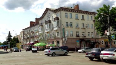 Nizhyn, Ukrayna - 23 Temmuz 2024: Nizhyn, Ukrayna 'da şehir hayatı. Arabaları ve eski apartmanları olan bir sokak..