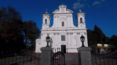 Korostyshiv 'deki barok kilisesinde demir kapılar ve fenerler var. Zhytomyr Oblastı, Ukrayna. Mavi gökyüzüne karşı simetrik cephe.