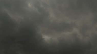 4K zaman dilimi stratocumulus koyu gri yuvarlanan bulutlar biraz mavi gökyüzü açıyor