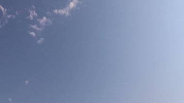 Güneşli bir günde mavi gökyüzü gradyanı üzerinde küçük bulutlar. Zaman Dilimi 4K