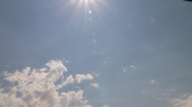 Güneş stratocumulus bulutlarını delip geçiyor mavi gökyüzünde. 4K zaman dilimi