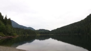 Kanada 'daki gölün zamanlaması ladin ormanı ve dağlarla çevrili.