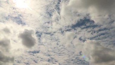Zaman ayarlı 4K sirokümülüs ve stratocumulus bulutları güneş arkadan parlıyor