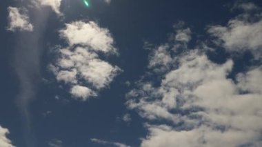 4K zaman ayarlı stratocumulus bulutları mavi gökyüzünde ve üzerinde güneş parıltısı