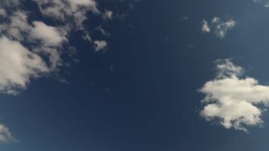 Az kümülüs bulutu hareket eden ve zaman dilimi oluşturan koyu mavi gökyüzü 4K