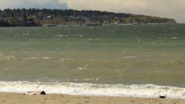 Burrard körfezi dalgaları Vancouver 'da kumlu bir plaja vuruyor rüzgarlı bir yaz gününde