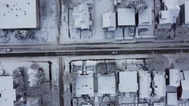 Karla kaplı ve siyah buzla kaplı yol manzarası. Arabalar yavaş gidiyor.