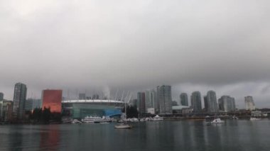 Timelapse of Vancouver downtown on an overcast day with boats passing by