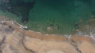 Enjoy 4K flyover of sunny beach and ocean.