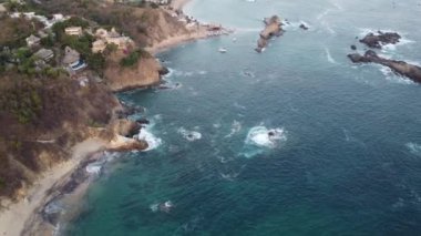 Okyanus kıyısının ve kayaların nefes kesici manzarasında uçuyor..