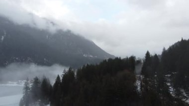 Serene Snowscape: Kanada 'daki Donmuş Göl' ün ortasındaki dağların İHA videosu