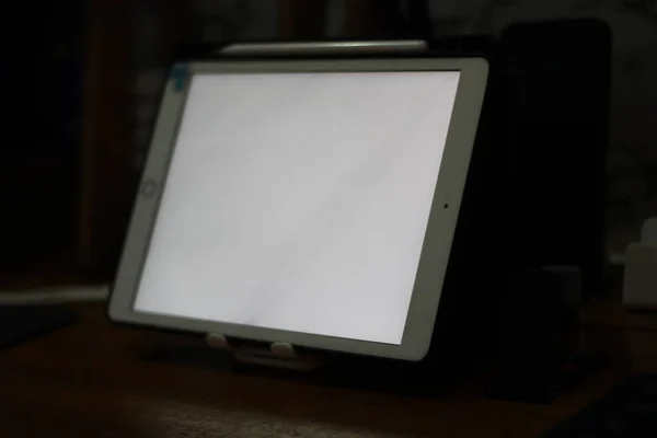 テーブルの上に白い画面のある空のタブレットの写真 — ストック写真