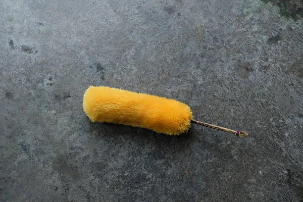 stock image yellow duster on black floor