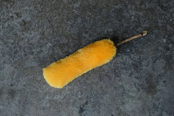 stock image yellow duster on black floor