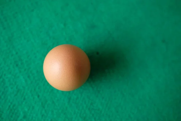 Yeşil Arka Planı Olan Bir Tavuk Yumurtasının Fotoğrafı — Stok fotoğraf