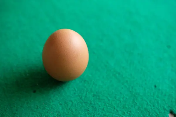 Yeşil Arka Planı Olan Bir Tavuk Yumurtasının Fotoğrafı — Stok fotoğraf