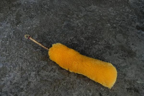 stock image yellow duster on black floor