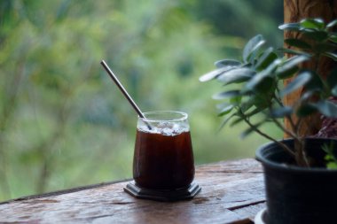 Masanın üzerinde sade kahve, yeşil arka planda.