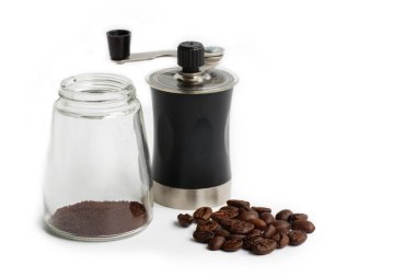 El yapımı kahve öğütücüsünde kahve çekirdeklerini öğütüp beyaz arka planı izole etmek.