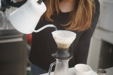 Kız kahve damlatma işlemi için makinede su hazırladı.