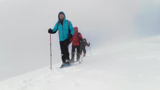 Turyści Plecakami Rakietami Śnieżnymi Spacerują Szlakiem Podczas Zimowej Wędrówki — Wideo stockowe