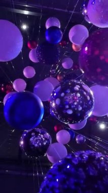 Dekoratif mavi ışıkta bir sürü Noel balosu. Kamera aşağıdan yukarıya hareket ediyor. Dikey video