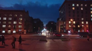 Kyiv, Ukrayna - 7 Kasım 2022: Arabalar karanlık bir sokaktan Khreshchatyk Caddesi 'ne doğru sürerler, sokak lambalarıyla aydınlatılırlar. Kiev 'in altyapısına yapılan Rus roket saldırıları sonucunda, şehirde elektrik sıkıntısı yaşandı.