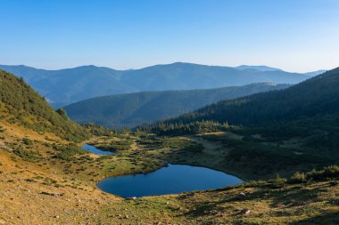 Mountain landscape with lake and mountains in the background on a sunny morning. 