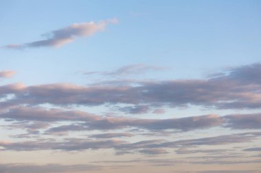 Clouds in the blue sky illuminated by the setting sun