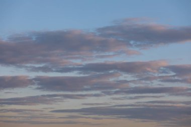 Clouds in the blue sky illuminated by the setting sun