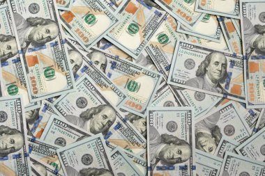 Hundred-dollar bills with a portrait of Benjamin Franklin in the background. Top view 