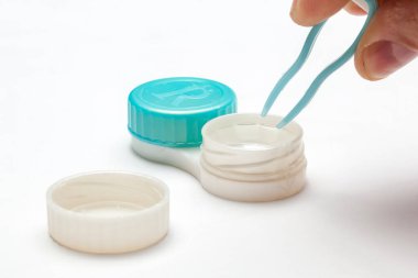 Cımbız ve kontak lensleri beyaz arka planda saklamak için bir konteynır. 