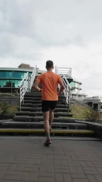 Paisaje Urbano Jog Camera Trailing Runner Orange Tee Escaleras Subida — Vídeos de Stock