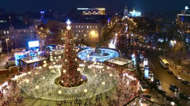 Ukrayna 'nın başkenti Kyiv' de Noel arifesinde Sofiyivska Meydanı 'ndaki Noel panayırını süsleyen çelenklerle süslenmiş bir Noel ağacı aydınlatıyor