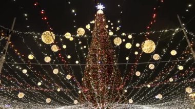 Akşamları bir sürü çelengi olan Noel ağacı