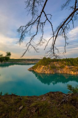 Bir akşam uçurumdan gelen turkuaz suyla göl manzarası