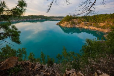 Güneşli bir yaz gününde gökyüzünde bulutlar olan turkuaz suyu olan bir göl.. 