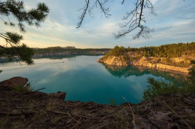 Güneşli bir yaz gününde gökyüzünde bulutlar olan turkuaz suyu olan bir göl.. 