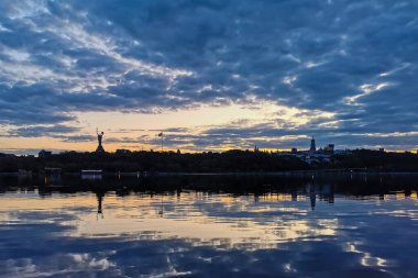 Ukrayna, Kiev 'de gün batımında gökyüzü çok güzel. Dinyeper Nehri 'nin sularına yansıyan güzel bulutlar. 