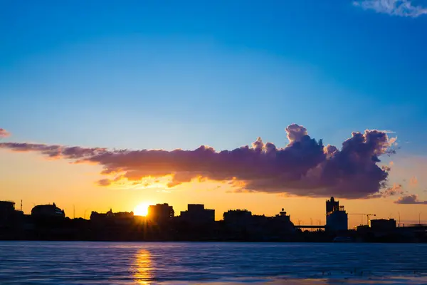 Tranquil Twilight: Şehir ve Nehir Üzerinde Güneş Batıyor