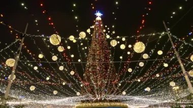 Akşamları bir sürü çelengi olan Noel ağacı