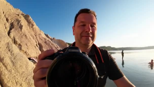 写真家が早朝に湖に下りる レンズ側からの眺め — ストック動画