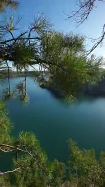 Yukarıdan güzel bir körfez manzarası. Güneşli bir yaz gününde turkuaz suyu olan bir göl manzarası. Dikey Video