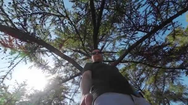 Homem Frente Céu Azul Coroa Uma Árvore Num Dia Ensolarado — Vídeo de Stock