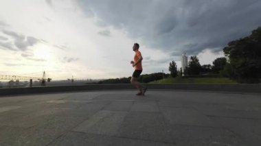 Canlı Sabah Koşusu: Turuncu gömlekli genç koşucu Kyiv Sunrise 'a karşı. UHD Video