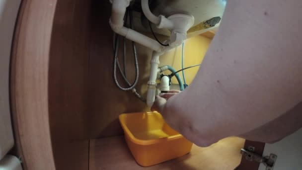 配管メンテナンス 男性はサービス後にキッチンシンクの下にU字型パイプを設置する — ストック動画