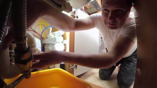 一名男子拆卸了水槽下的水管 以便清洁和维修 它断开U形管道用于排水和清洁 — 图库视频影像